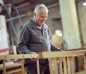 Un ouvrier menuisier en blouse dans l'usine.